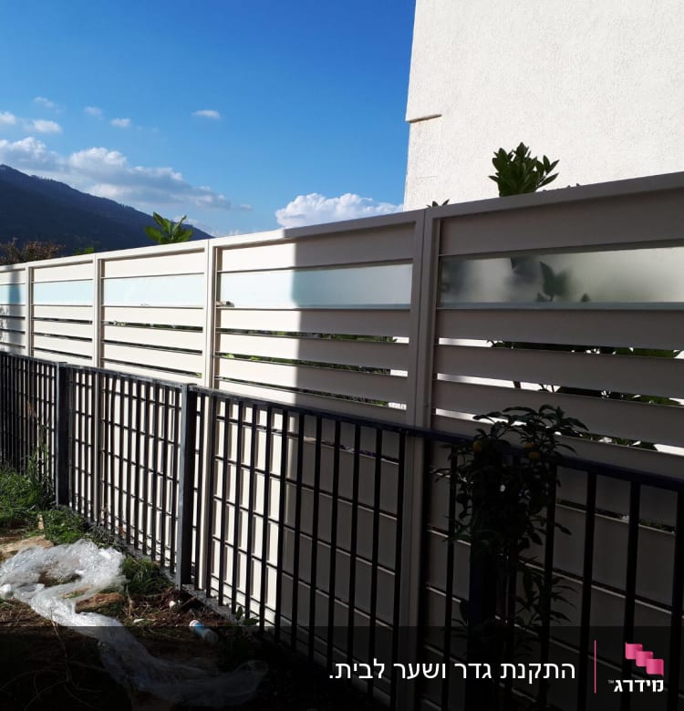 גדרות מתכת ולוחות זכוכית חלבית בחצר